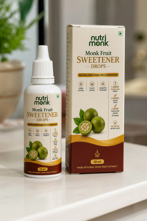 A bottle and box of nutri monk Monk Fruit Sweetener Drops displayed on a white surface with a blurred indoor background.